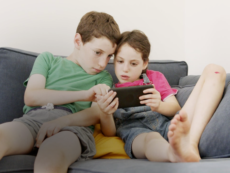 image of two young boys looking at a nintendo switch