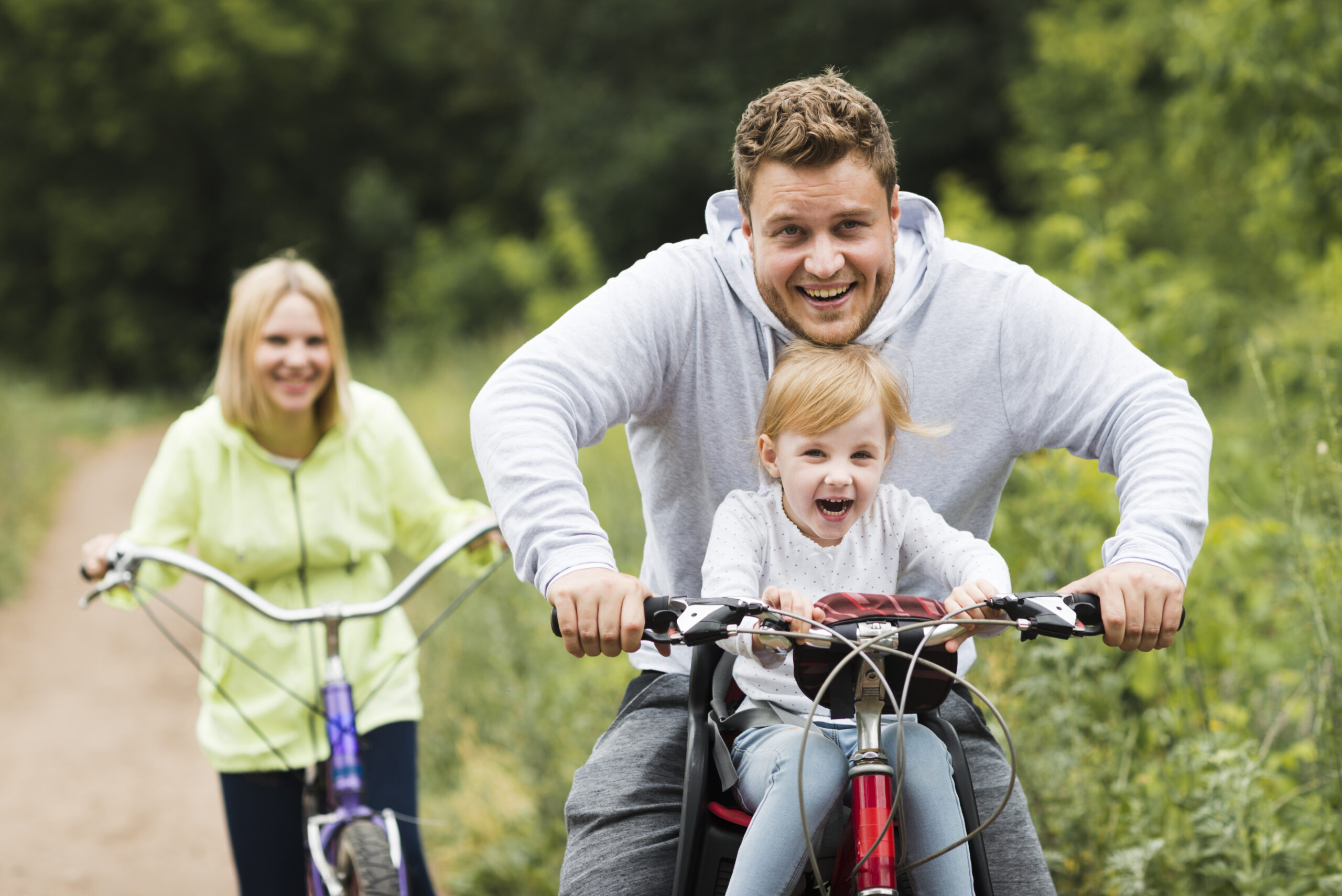 father and mother on a bike ride with child