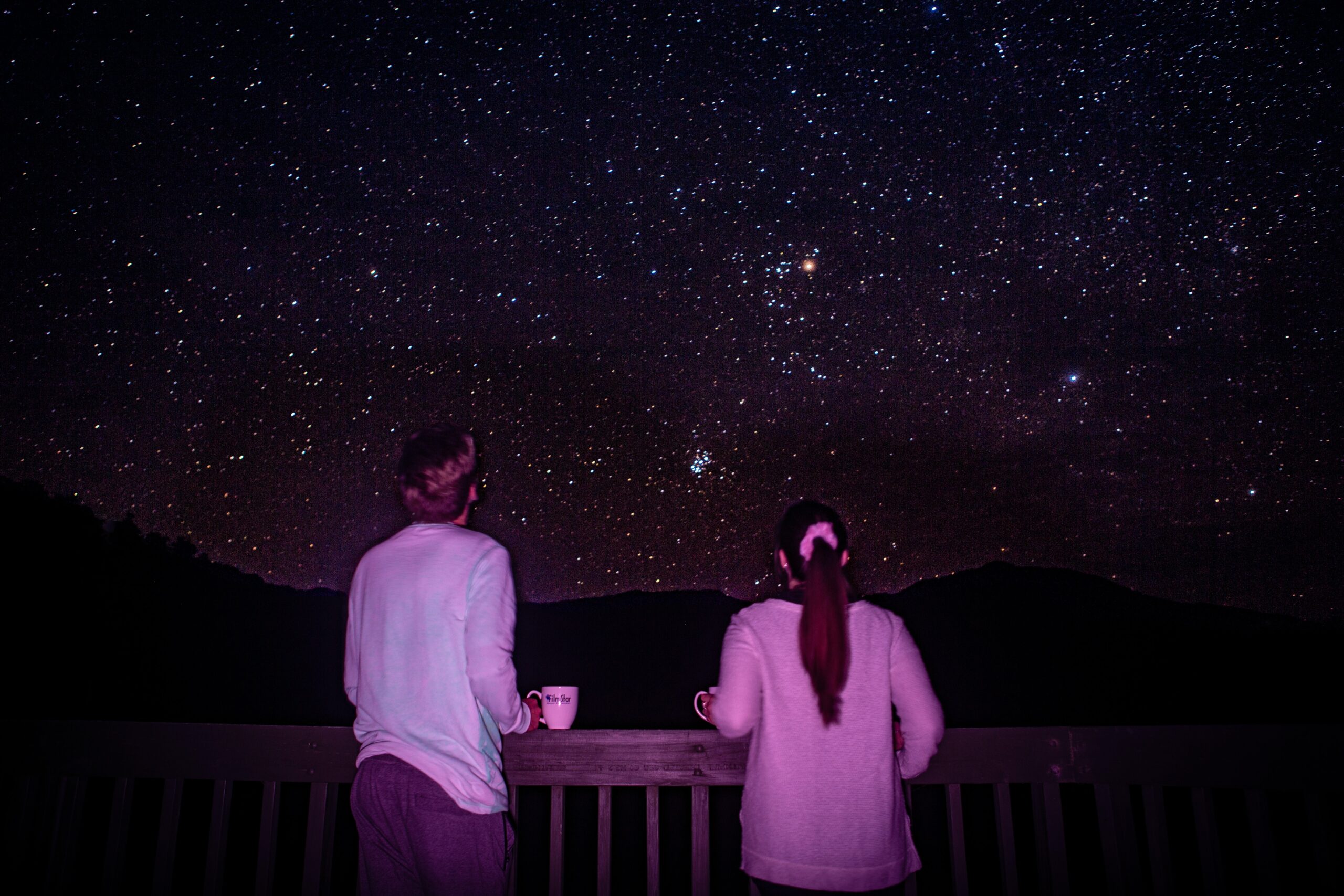 young male and female looking us at stars