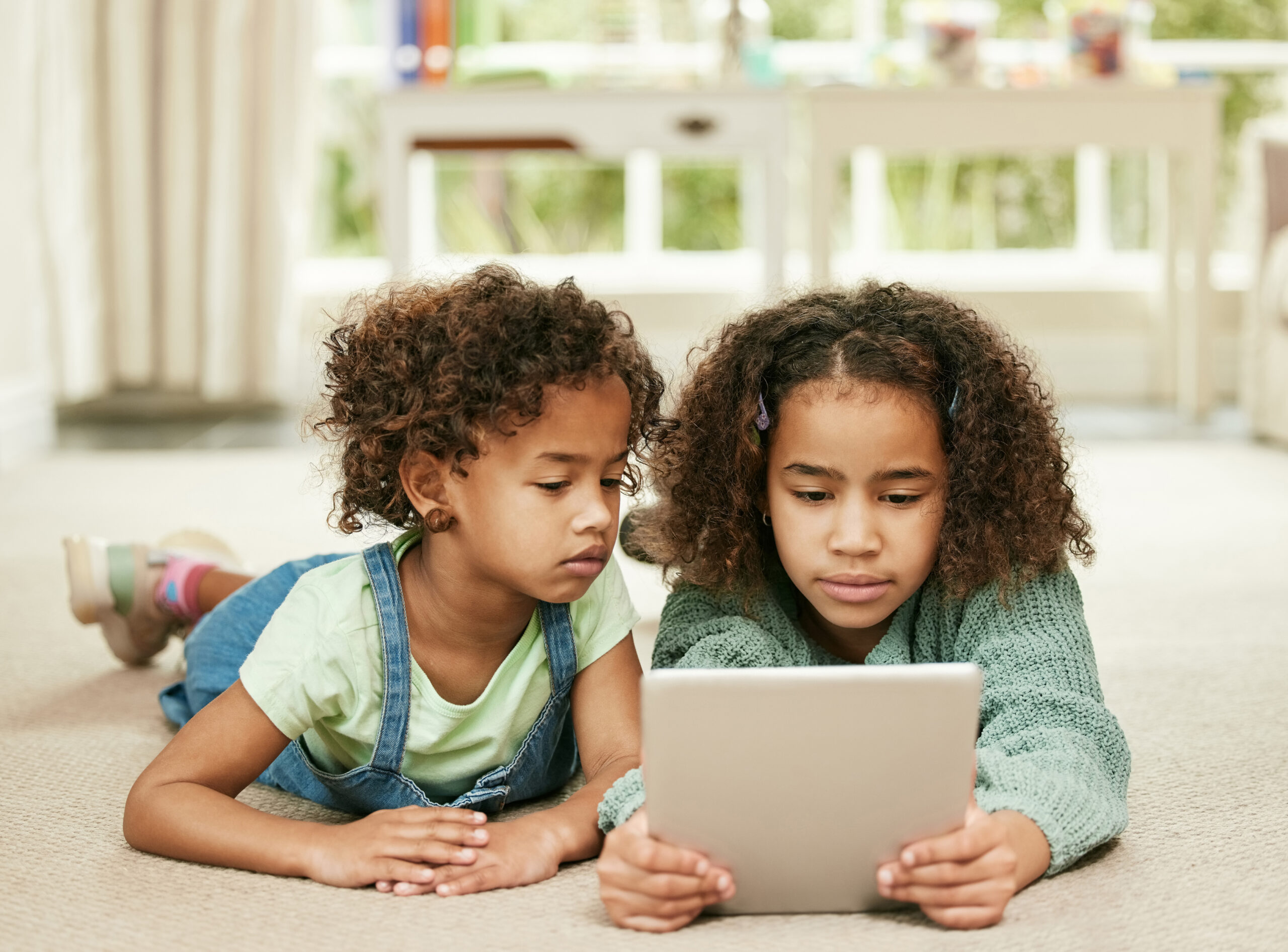 Theyre glued to the screen. Shot of two sisters using a digital